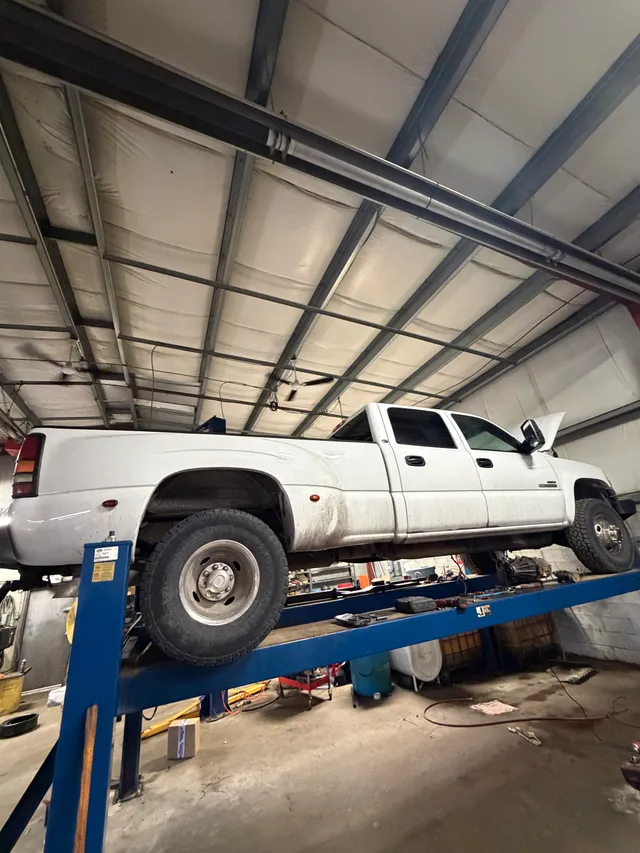 White pickup on a workshop lift
