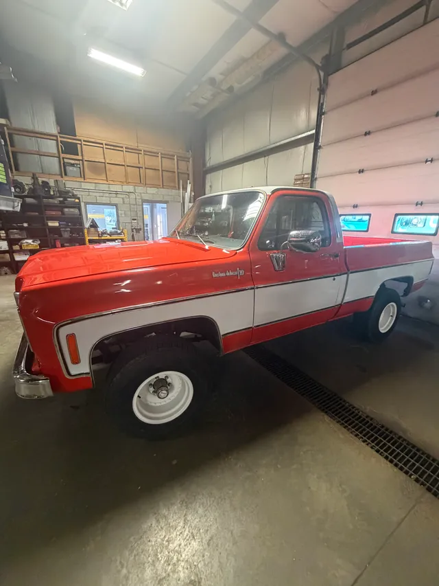 Red and white classic pickup inside the workshop