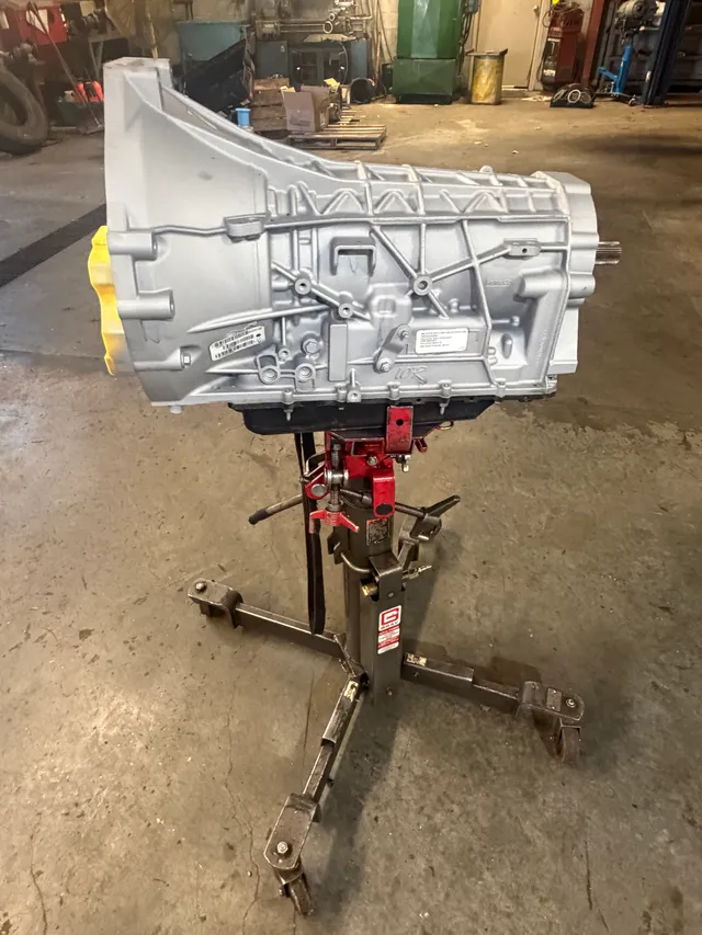 Silver transmission on a red stand inside the workshop